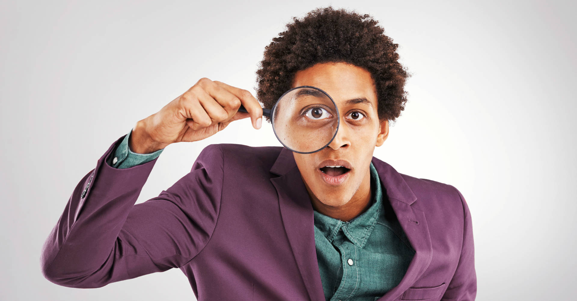 man looking through magnifying glass