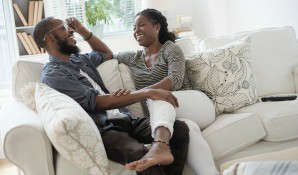 man and woman laughing on couch