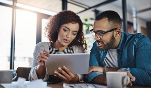 man and woman looking at tablet