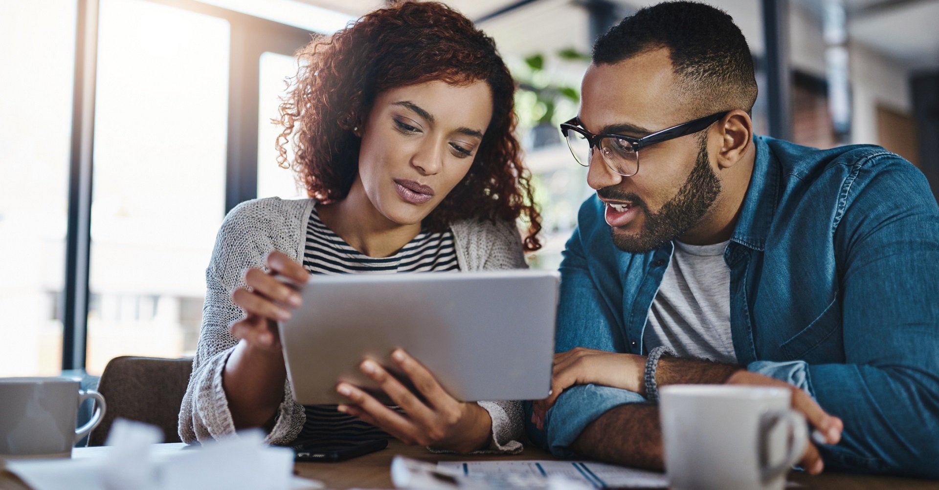 man and woman looking at tablet