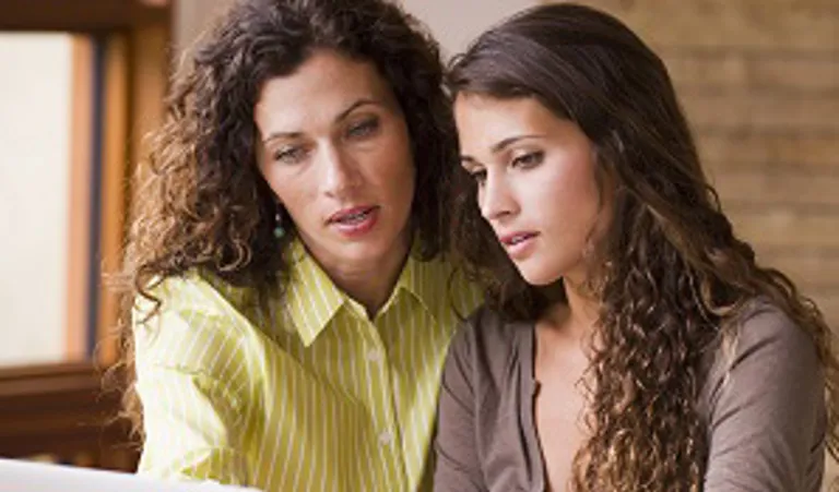 Mother and daughter looking at laptop