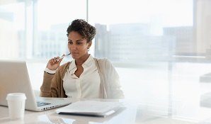 Woman sitting at computer thinking