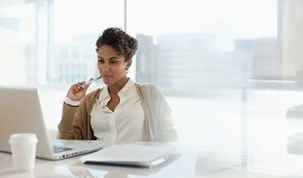 Woman sitting at computer thinking