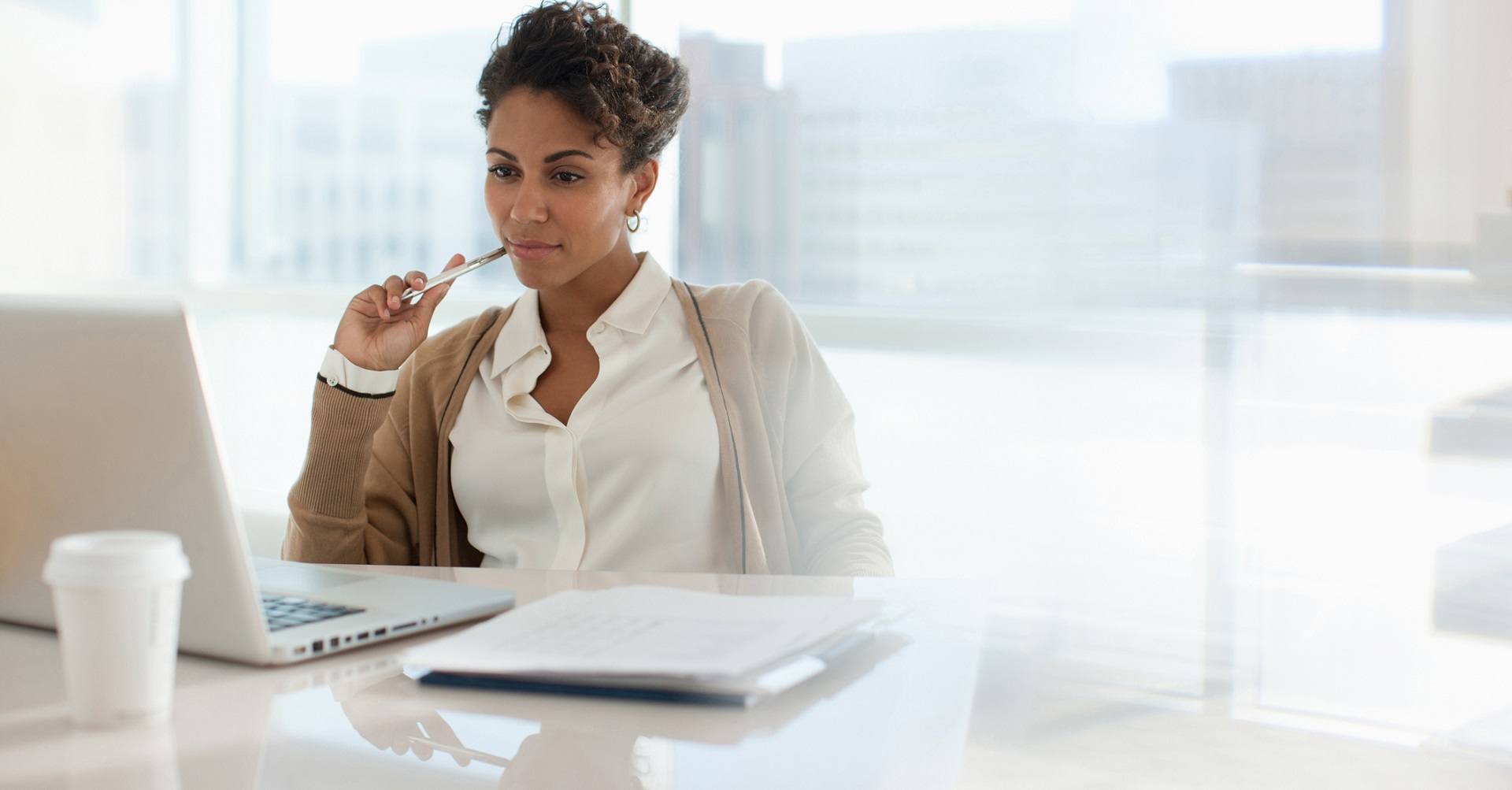 Woman sitting at computer thinking