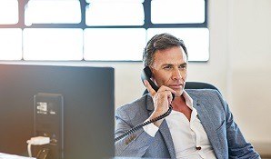 Man sitting at desk on the phone