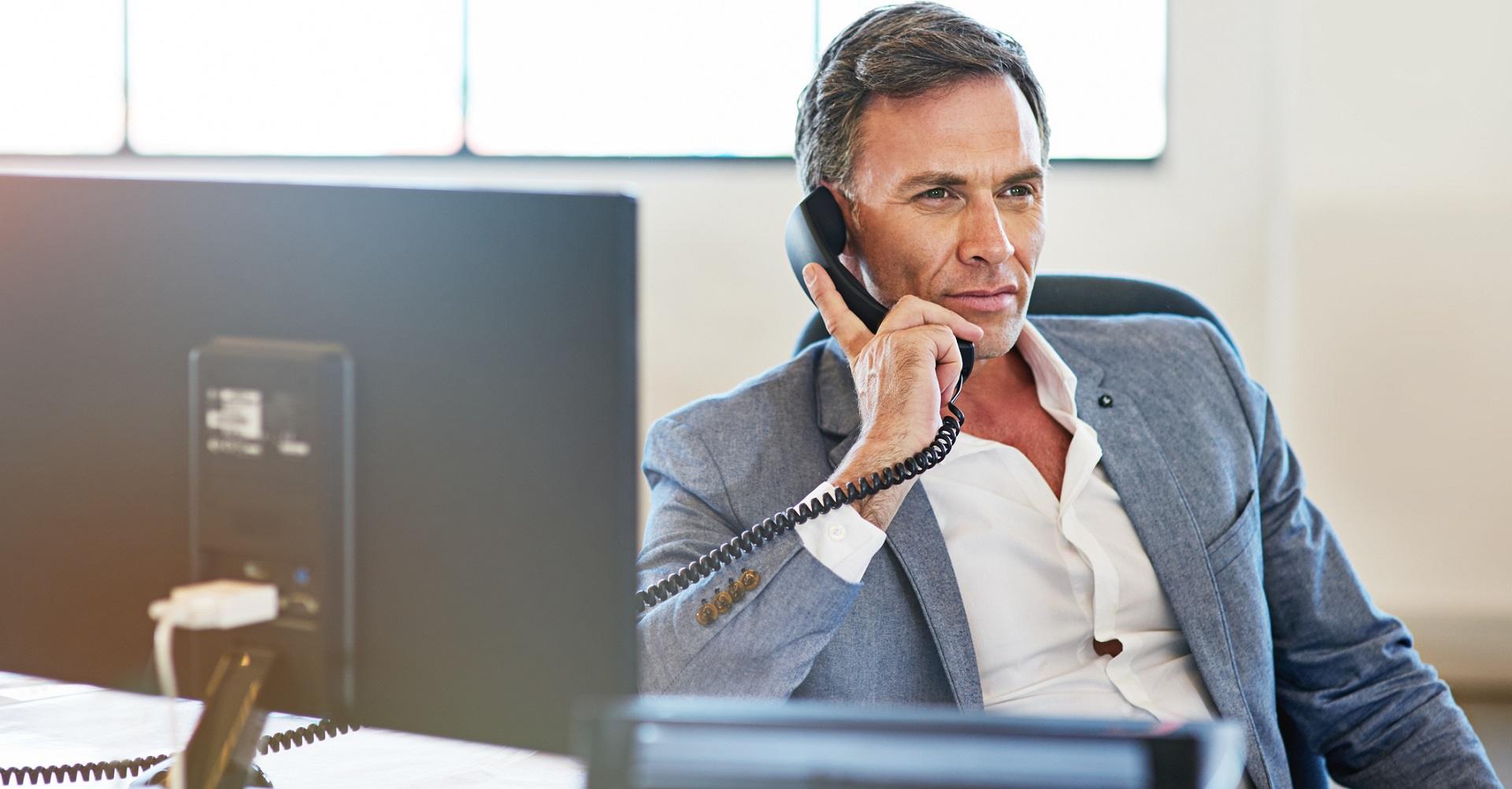 Man sitting at desk on the phone