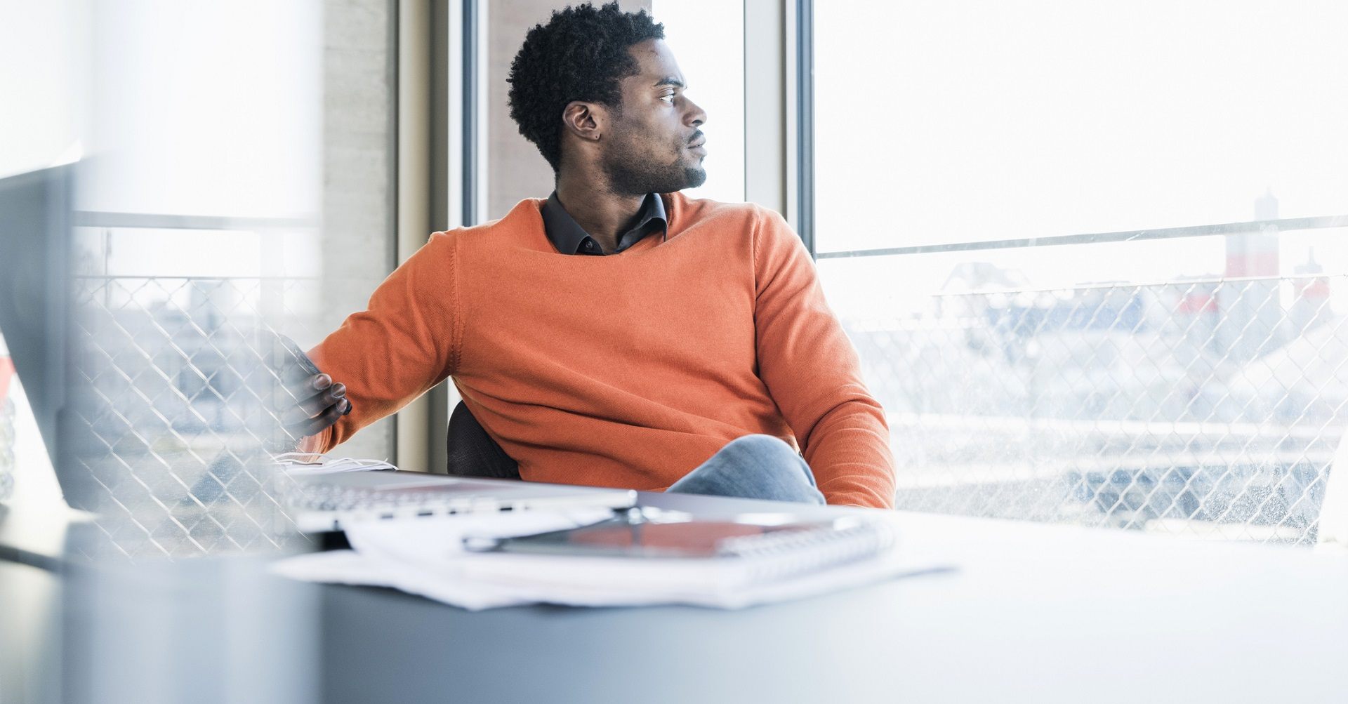 Man sitting at desk looking out window