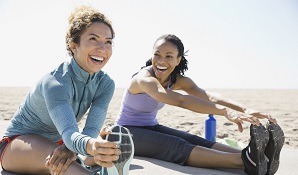 Women on beach stretching