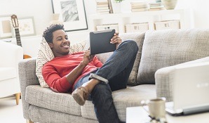 Man sitting on couch with tablet