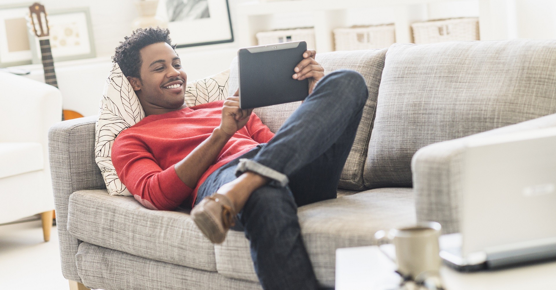 Man sitting on couch with tablet