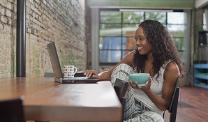 Woman sitting at desk eating breakfast