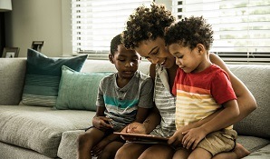 mother on couch with sons and tablet