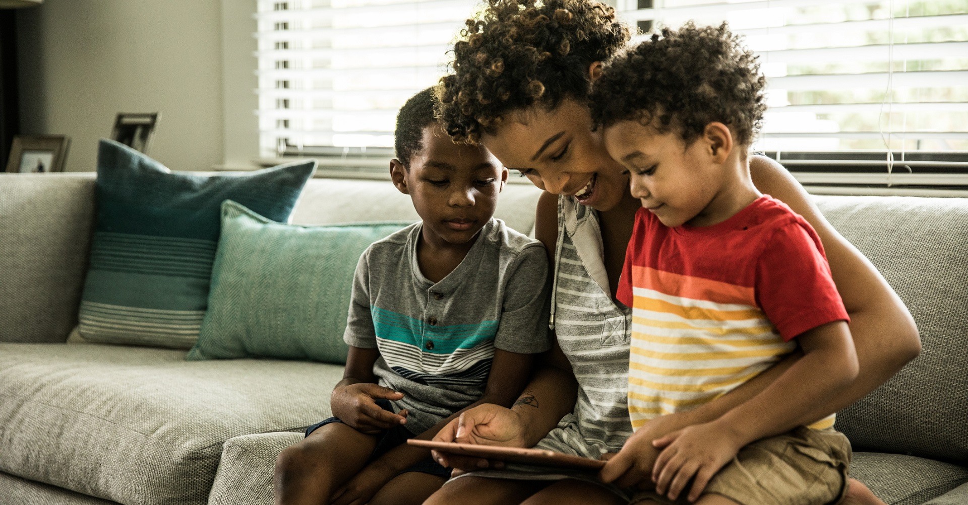 mother on couch with sons and tablet