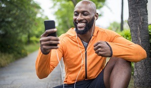 Man sitting on bench in workout clothes on cellphone