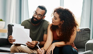 couple sitting on couch doing finances