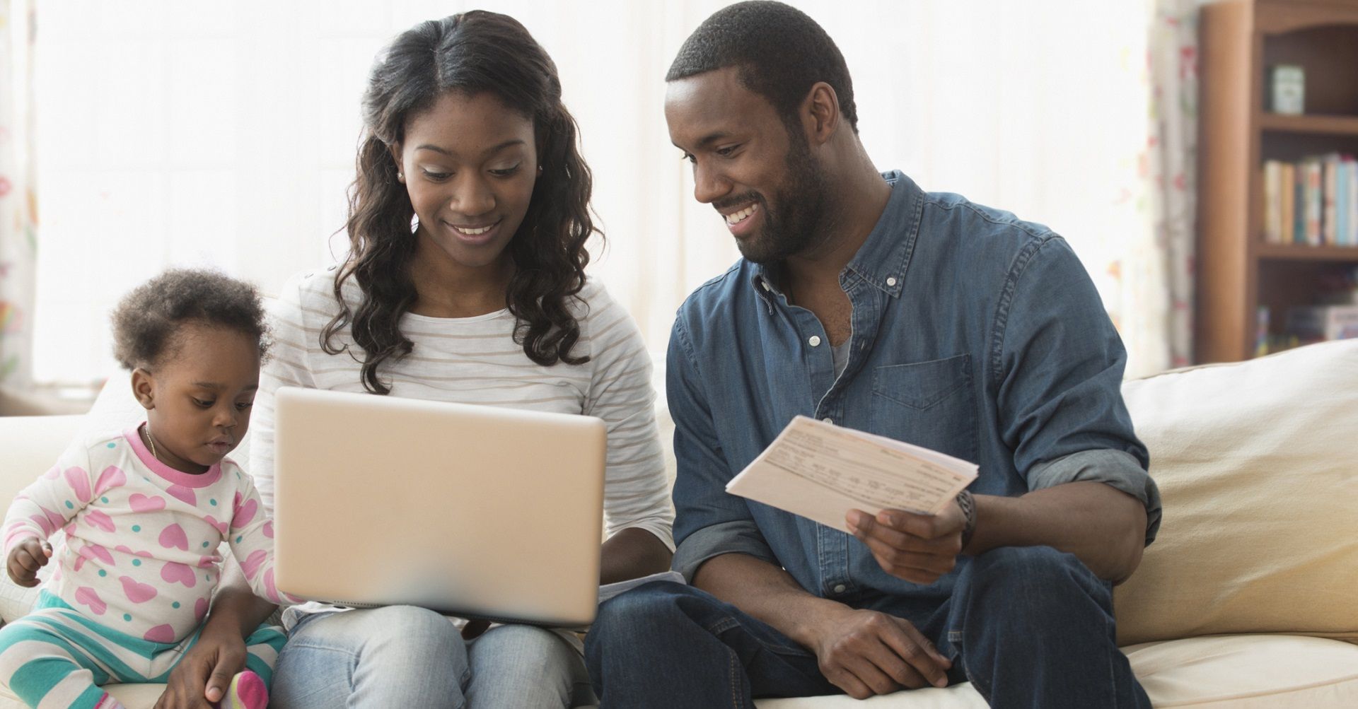 Family sitting on couch looking at laptop