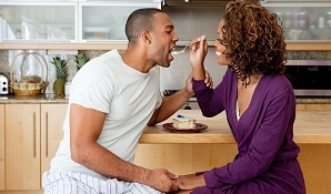 Woman feeding cake to boyfriend