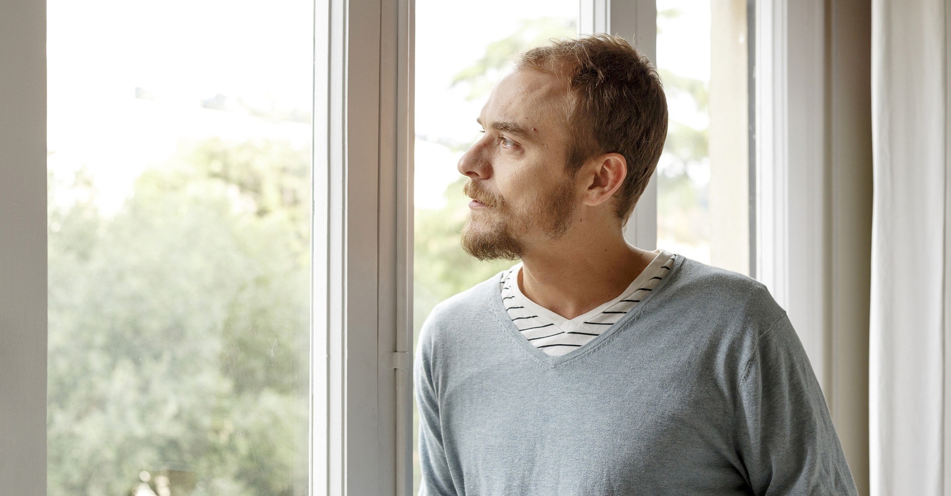 man looking out window