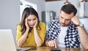 Worried couple working out investments