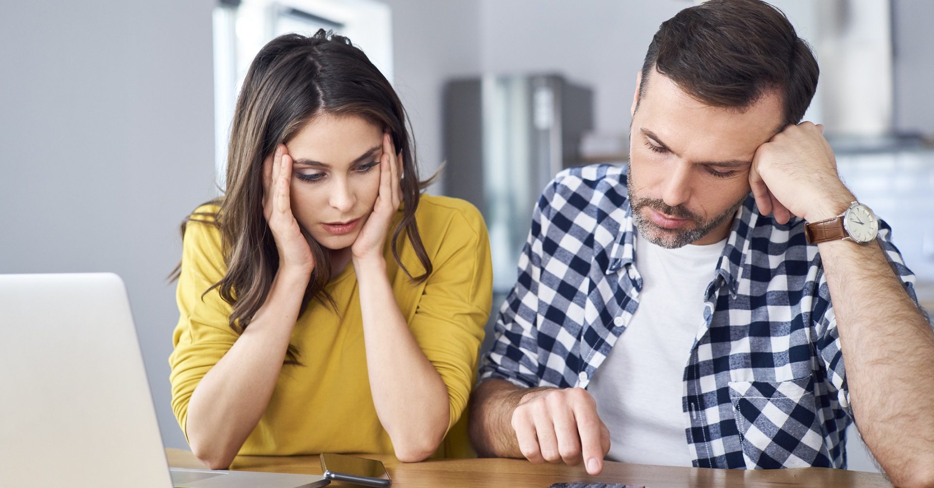 Worried couple working out investments