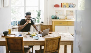 man sitting at table with laptop