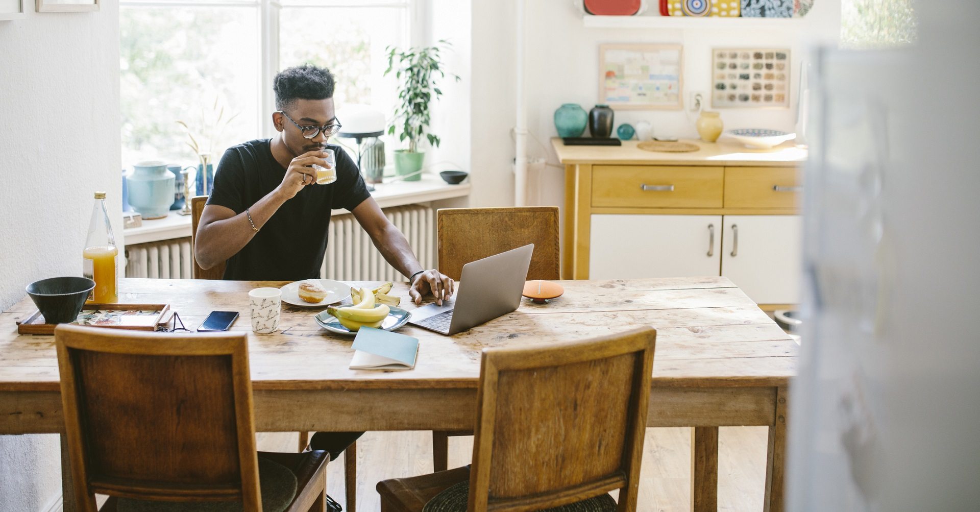 man sitting at table with laptop