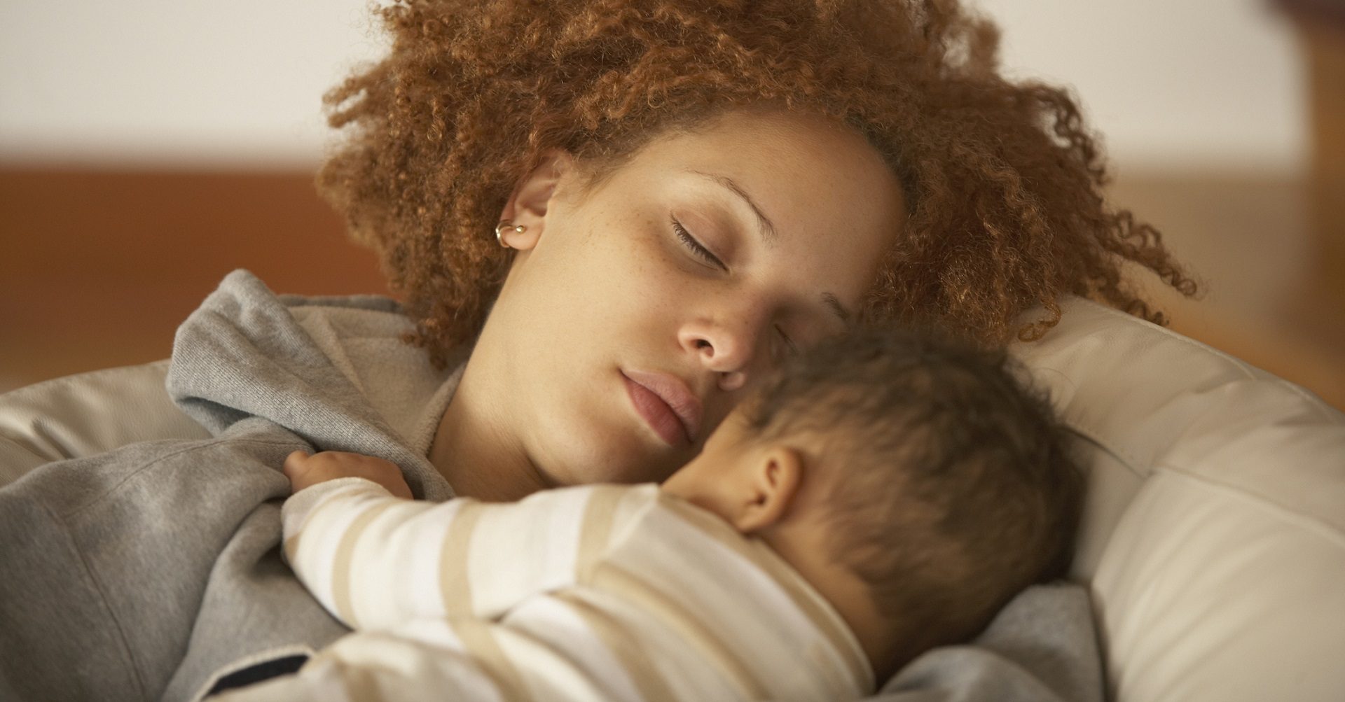 mother sleeping with baby on chest