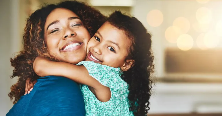 Mother hugging daughter