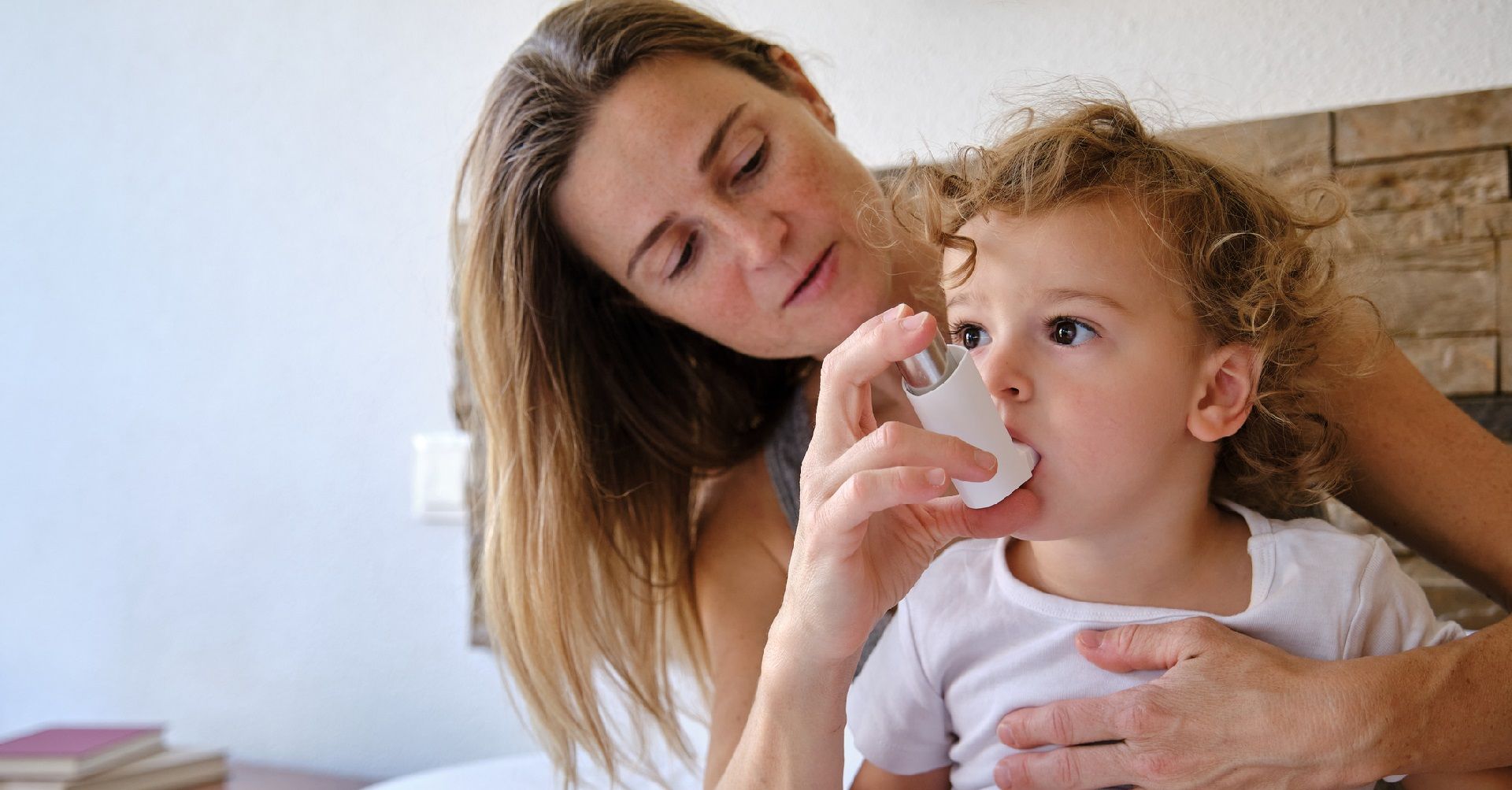 Mother assisting child with asthma inhaler