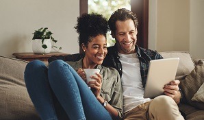 Couple sitting on couch with tablet