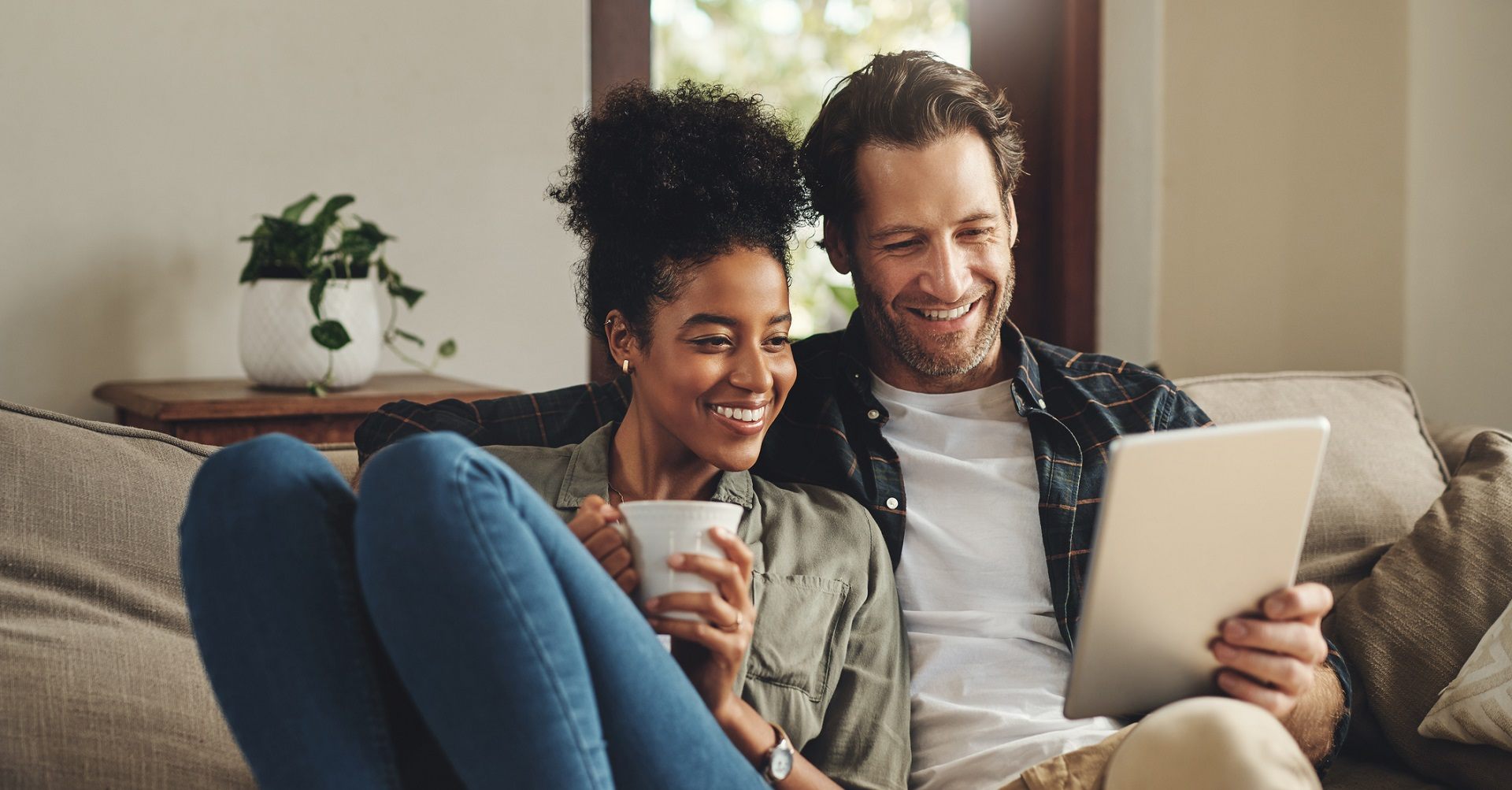 Couple sitting on couch with tablet