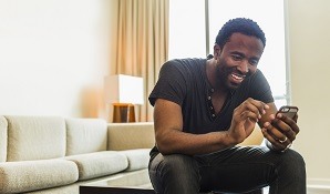 Man on cellphone sitting at home