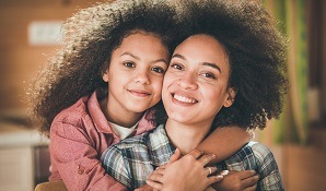 Child hugging mother from behind