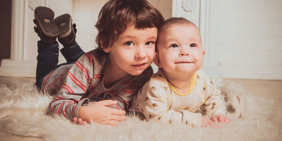 Two children laying on the floor smiling