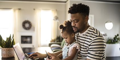 Man sitting at laptop with child