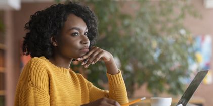 Woman thinking in front of laptop