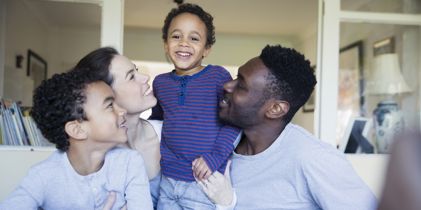 Family of 4 looking at each other and smiling