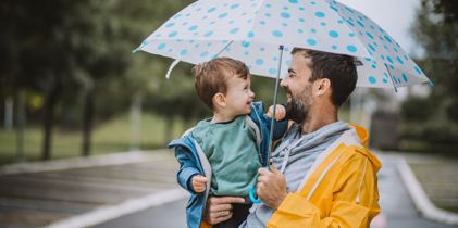 man with umbrella holding child