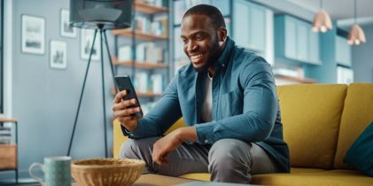 Man sitting on couch looking at his phone