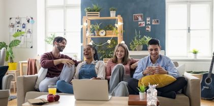 Young adults sitting on a couch laughing