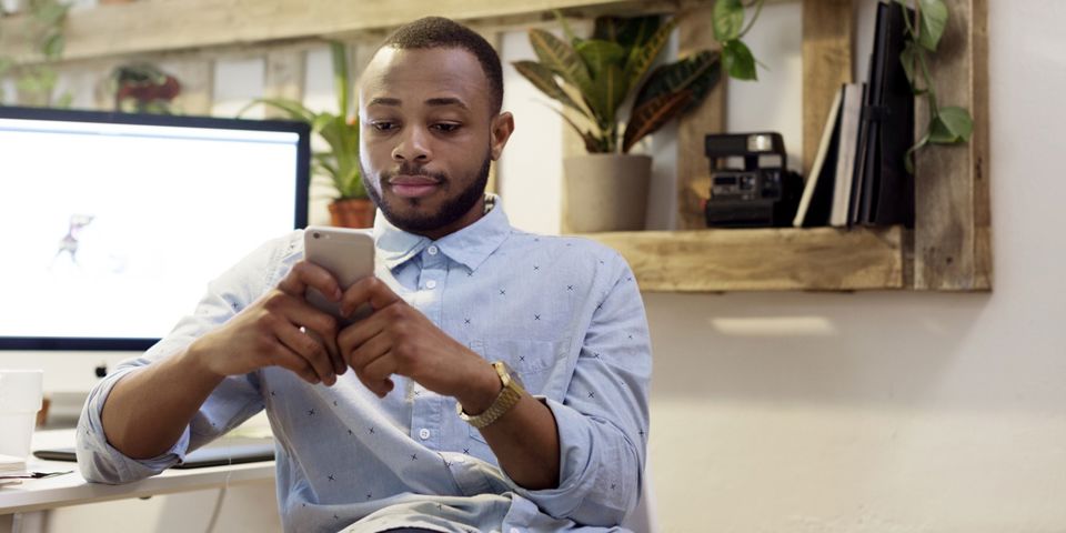man on cellphone at desk