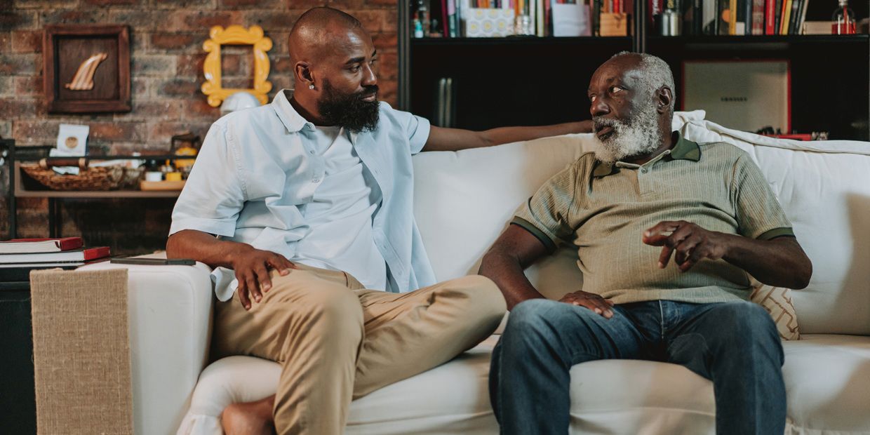 Adult man talking to father on couch