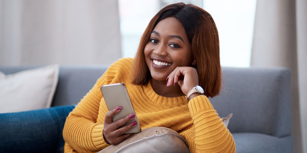 woman on couch holding cellphone