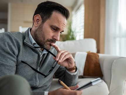 Man looking at phone and thinking