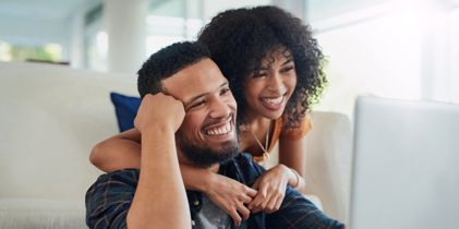 couple embracing and looking at laptop