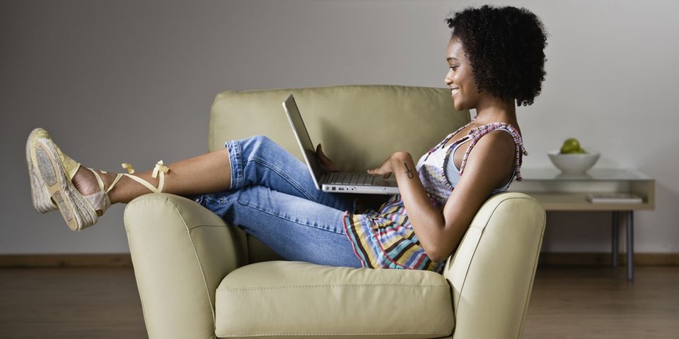 woman lounging on couch with laptop
