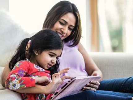 Mother with daughter on tablet