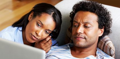 couple looking at laptop looking concerned