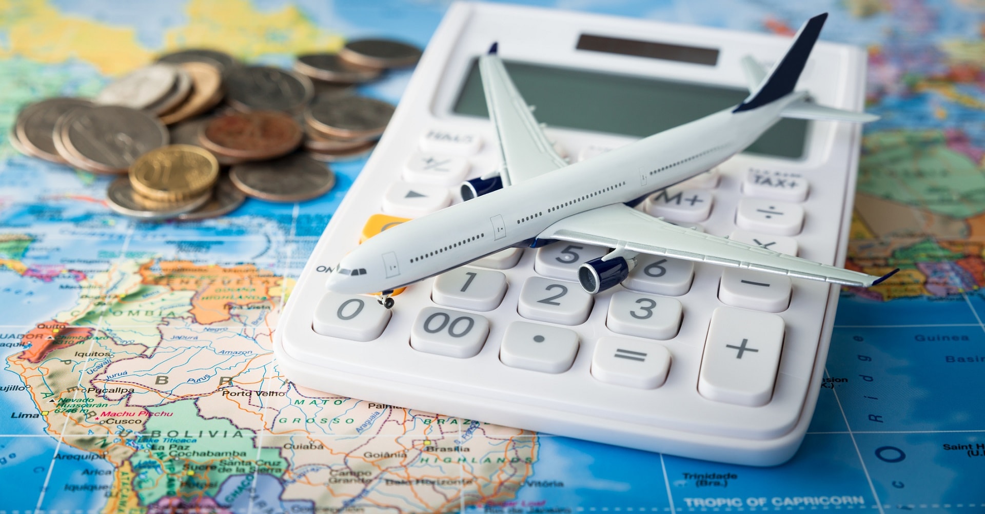 Calculator with aeroplane on top of world map