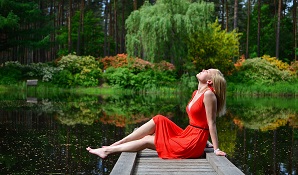 relaxed woman sitting next to river